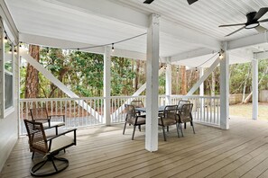 A covered outdoor patio with white railings, a table with chairs, and a ceiling fan. - Coastal 30A Retreat - 4BR - Sleeps 8 - Walk to Beach (Santa Rosa Beach)