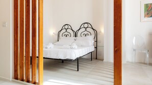 Una camera da letto con un letto, doghe in legno e una sedia trasparente.