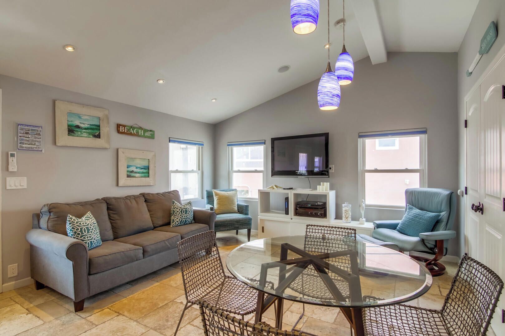 A living room with a sofa, chairs, a TV, and a fireplace.