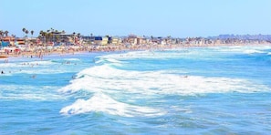 A beach with waves and people swimming. - Steps 2 Beach, Great for Couples W/Parking, Amazing Reviews! (San Diego)