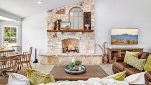 Una sala de estar con chimenea de piedra, muebles de madera y un cuadro en la pared.
