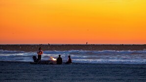 A sunset over the ocean with people sitting on the beach. - Perfect For Families, Steps To Beach, Close to Everything! (San Diego)