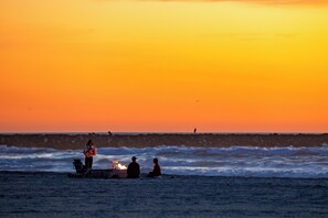 A sunset over the ocean with people sitting on the beach. - Perfect For Families, Steps To Beach, Close to Everything! (San Diego)