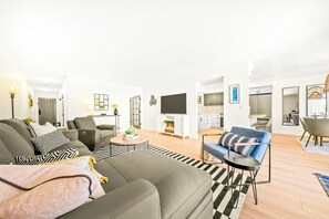 Ein modernes Wohnzimmer mit einer Couch, einem Couchtisch und einem Flachbildfernseher.