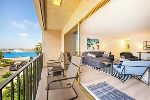 A balcony with seating, a view of the sea, and a living area with a sofa and coffee table. - Pet Friendly 2 bedroom in Point Loma Overlooking Kellogg Beach - Stay for 30 days! (San Diego)