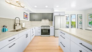 A modern kitchen with white cabinets, a stainless steel oven, and a refrigerator. - Pet Friendly 2 bedroom in Point Loma Overlooking Kellogg Beach - Stay for 30 days! (San Diego)