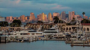 A marina with several yachts docked, a city skyline in the background, and a cloudy sky. - Pet Friendly 2 bedroom in Point Loma Overlooking Kellogg Beach - Stay for 30 days! (San Diego)