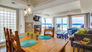 Un'ampia zona giorno con un tavolo da pranzo in legno, sedie, un divano e una TV.