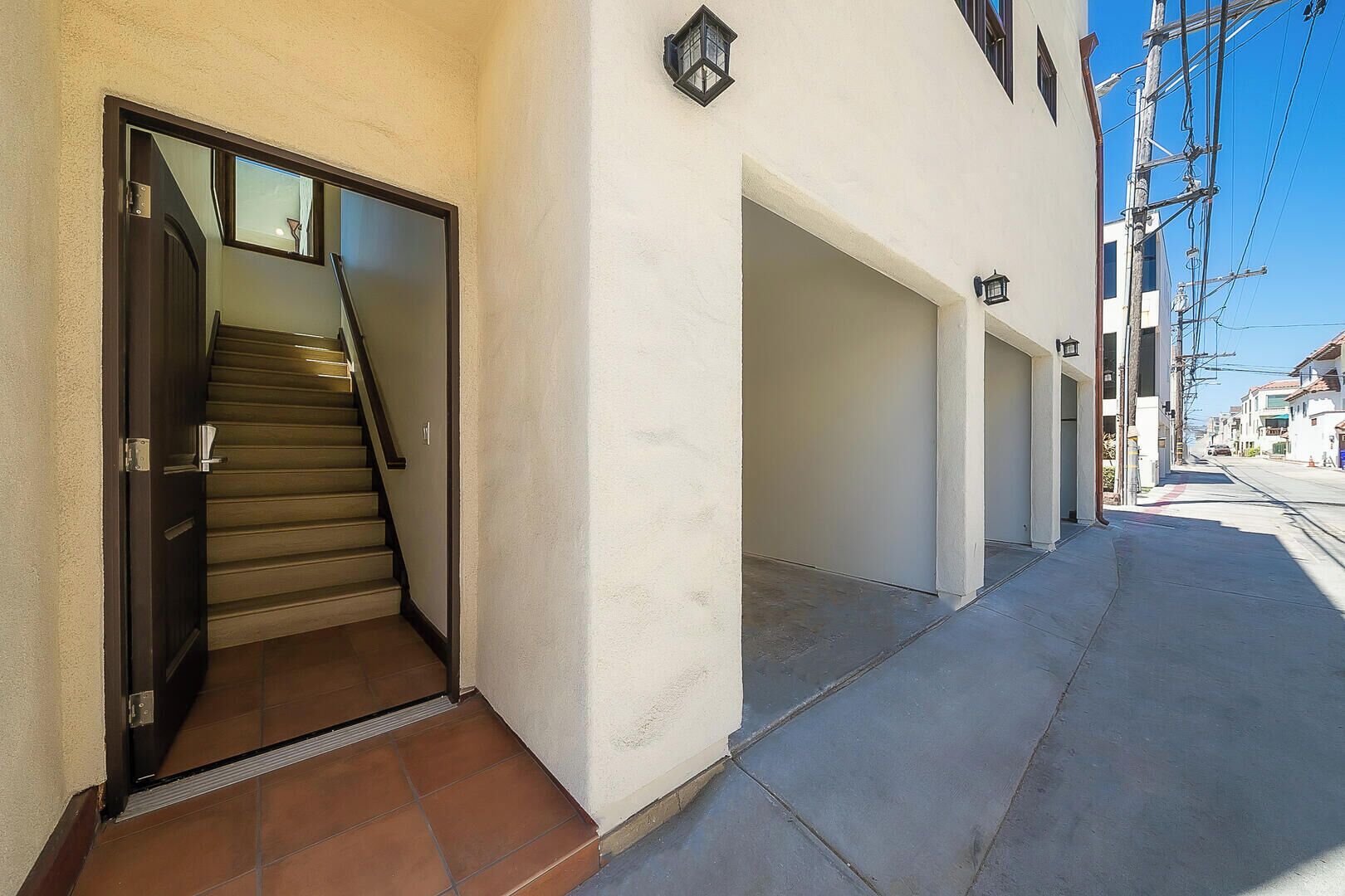 Un stretto vicolo con una scala che conduce a una porta, un marciapiede e edifici su entrambi i lati.