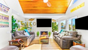 A living room with two sofas, a coffee table, a fireplace, and a ceiling fan. - Perfect for Families,Steps to the Beach W/Parking! (San Diego)