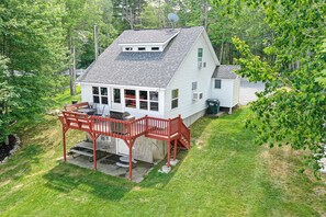 A two-story house with a covered patio and a small shed.