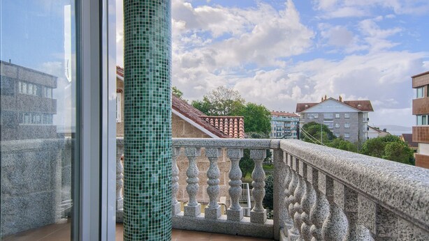 A balcony with a stone balustrade and a view of surrounding buildings. - Pontus Veteris (Sanxenxo)