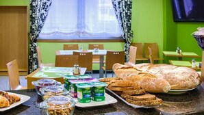 A breakfast buffet with bread, pastries, and yogurt containers. - Pontus Veteris (Sanxenxo)