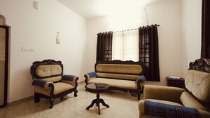 A living room with a sofa, two armchairs, a coffee table, and a small side table. - 3-bedroom house in peaceful Alappuzha with AC comfort (Alappuzha)