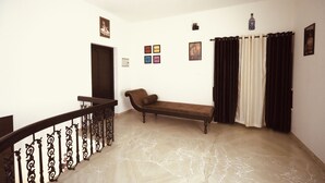 A room with a marble floor, a bench, a door, and a staircase with ornate railings. - 3-bedroom house in peaceful Alappuzha with AC comfort (Alappuzha)