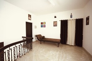 A room with a marble floor, a bench, a door, and a staircase with ornate railings. - 3-bedroom house in peaceful Alappuzha with AC comfort (Alappuzha)