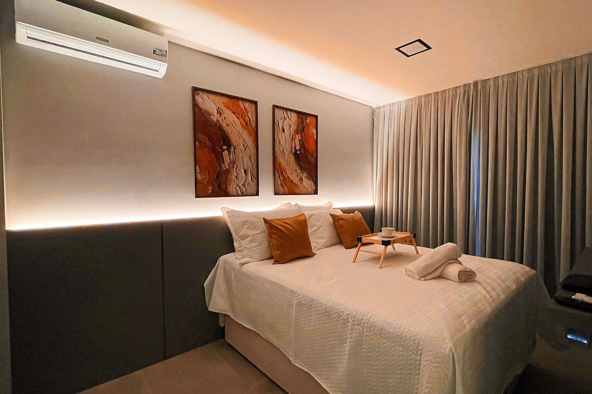 Une chambre d’hôtel moderne dotée d’un grand lit, d’un téléviseur à écran plat et d’un climatiseur fixé au mur.