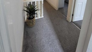 Ein Flur mit Treppe, einer Hängelampe und einer Pflanze.
