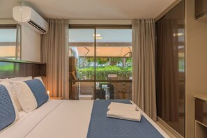 Ein Hotelzimmer mit einem großen Bett, Blick ins Freie und einer Klimaanlage.