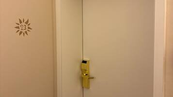 A closed door with a golden handle and a sun-shaped decoration on the wall.