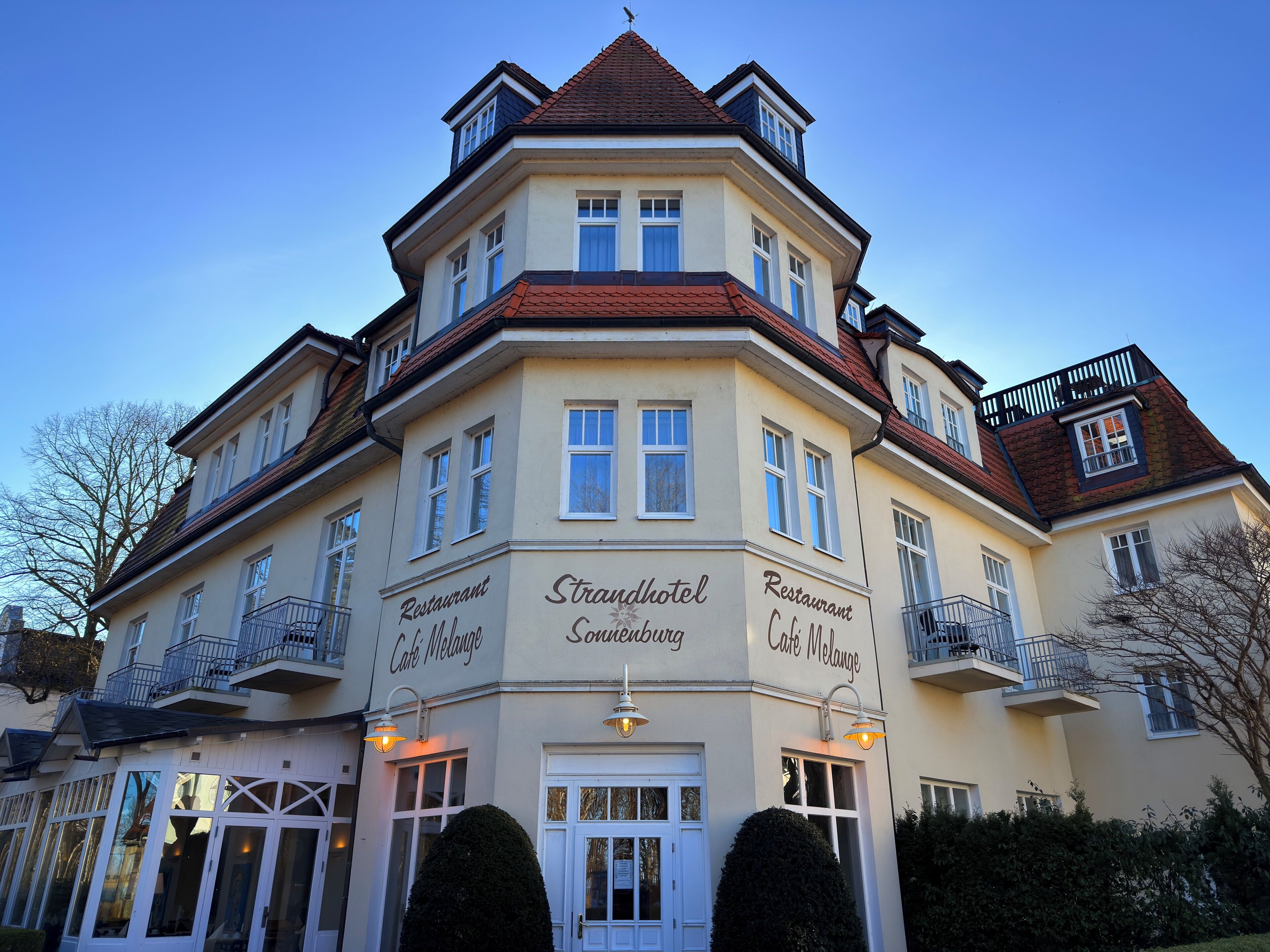 A multi-story building with a corner entrance, labeled as 'Strandhotel Sonnenburg' and 'Restaurant Café Melange.'