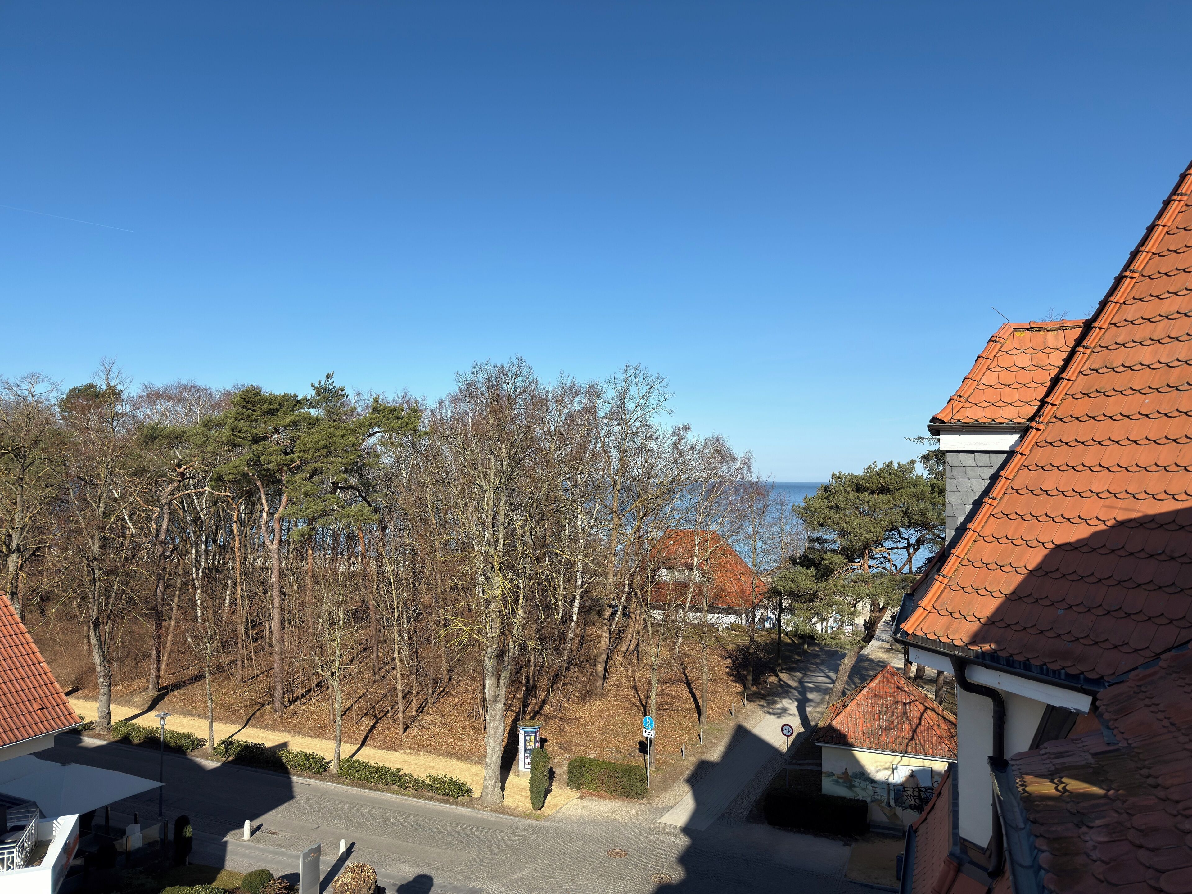 Un quartiere residenziale con case, alberi e cielo sereno.