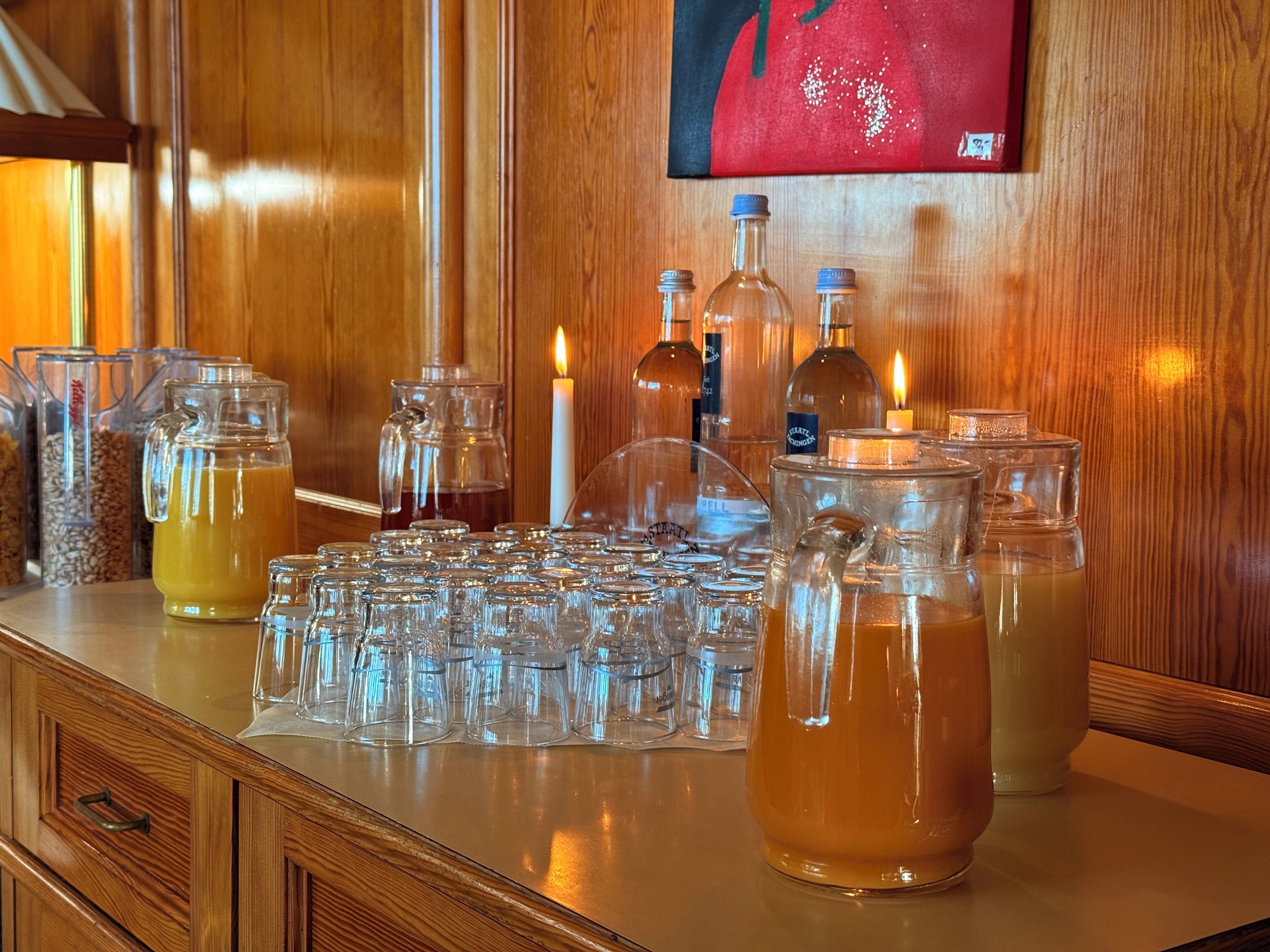 A bar area with multiple glassware, bottles, and a candle.