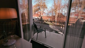 A room with a view of trees and a parking area through a window. - Strandhotel Sonnenburg by ANS (Kuehlungsborn)