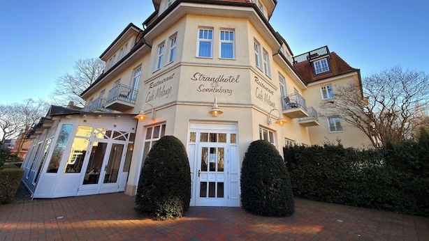 A multi-story building with signage for 'Restaurant Café Melange' and 'Strandhotel Sonnenburg.' - Strandhotel Sonnenburg by ANS (Kuehlungsborn)