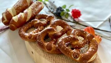 Een houten plank met pretzels en een rolletje gebak.