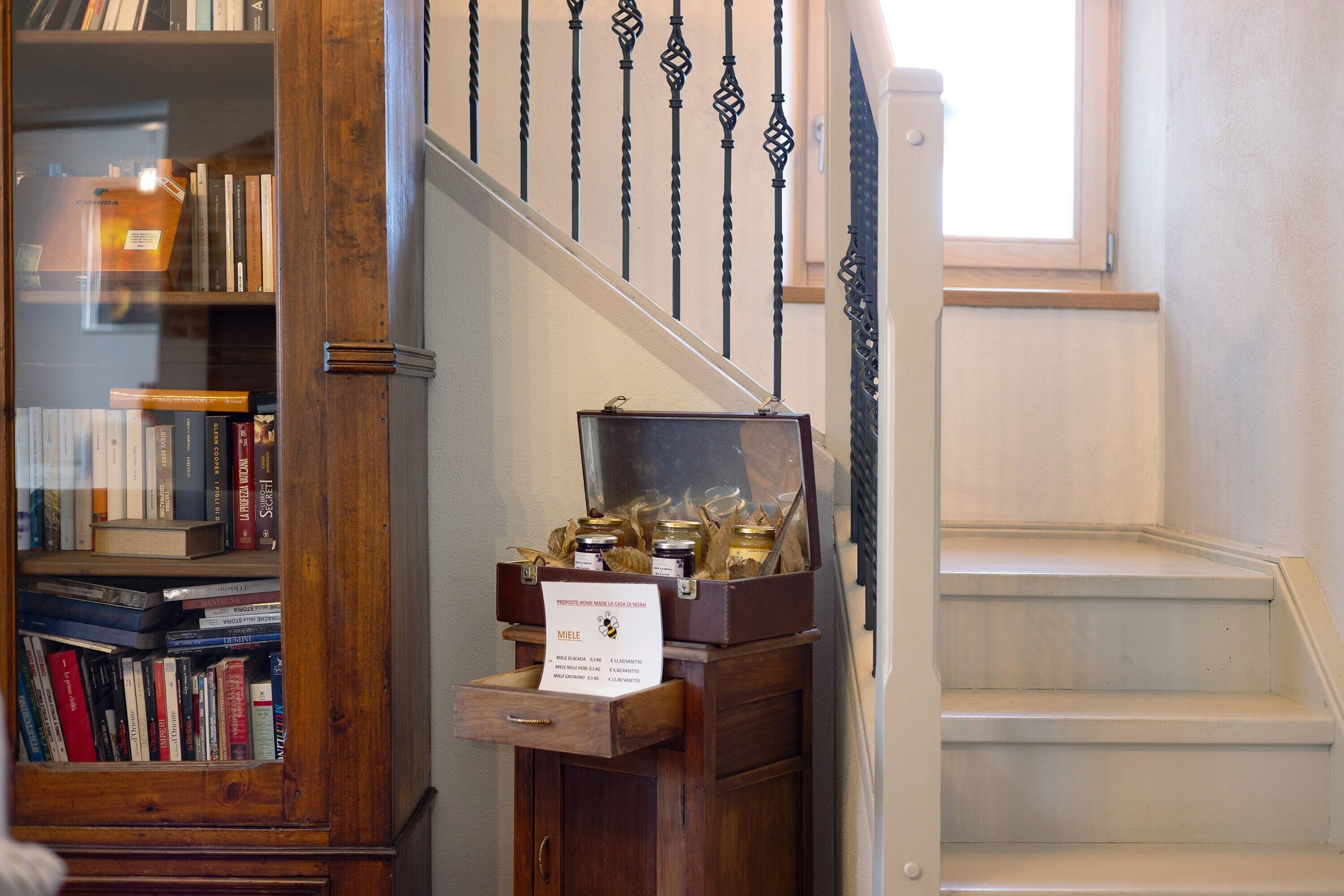 Een trap met een houten leuning en een boekenplank vol boeken.
