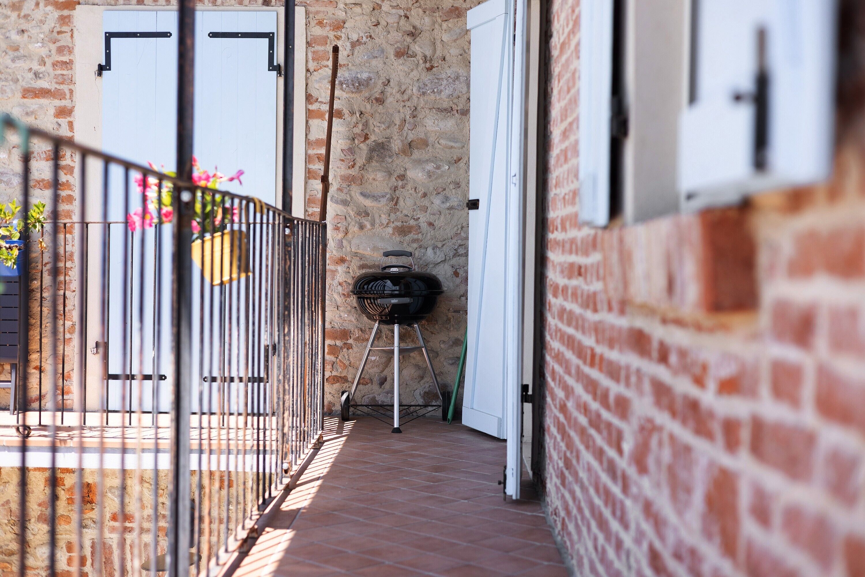 A brick building with a balcony, a grill, and a door.