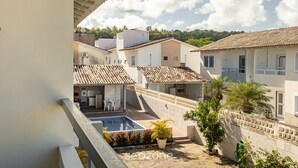 Et boligområde med swimmingpool, overdækket terrasse og udsigt til naboliggende huse.