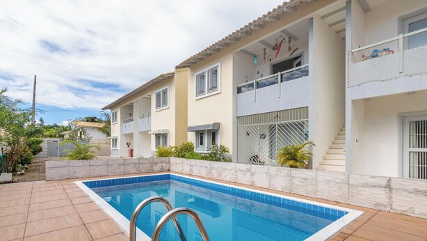En boligbygning med swimmingpool, låste porte og en balkon med udsigt.