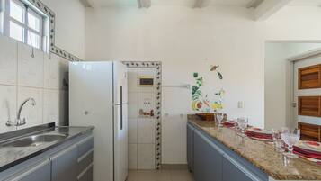 A kitchen with a stainless steel sink, a white refrigerator, and a granite countertop.