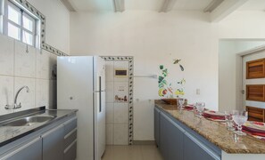 A kitchen with a stainless steel sink, a white refrigerator, and a granite countertop. - Condo w/ Pool and BBQ Grill - ART (Porto Seguro)