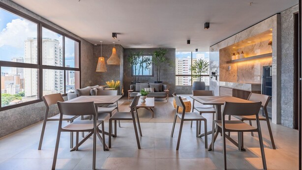 Een modern interieur met grote ramen, een eethoek, een zithoek en een keuken.