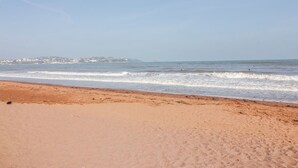 Ein Strand mit klarem Himmel und Wellen.