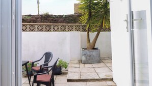 Eine Terrasse mit einem Blumentopf, einem kleinen Tisch und zwei Stühlen.