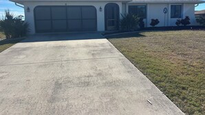 Een gelijkvloers huis met garage, voortuin en heldere lucht.