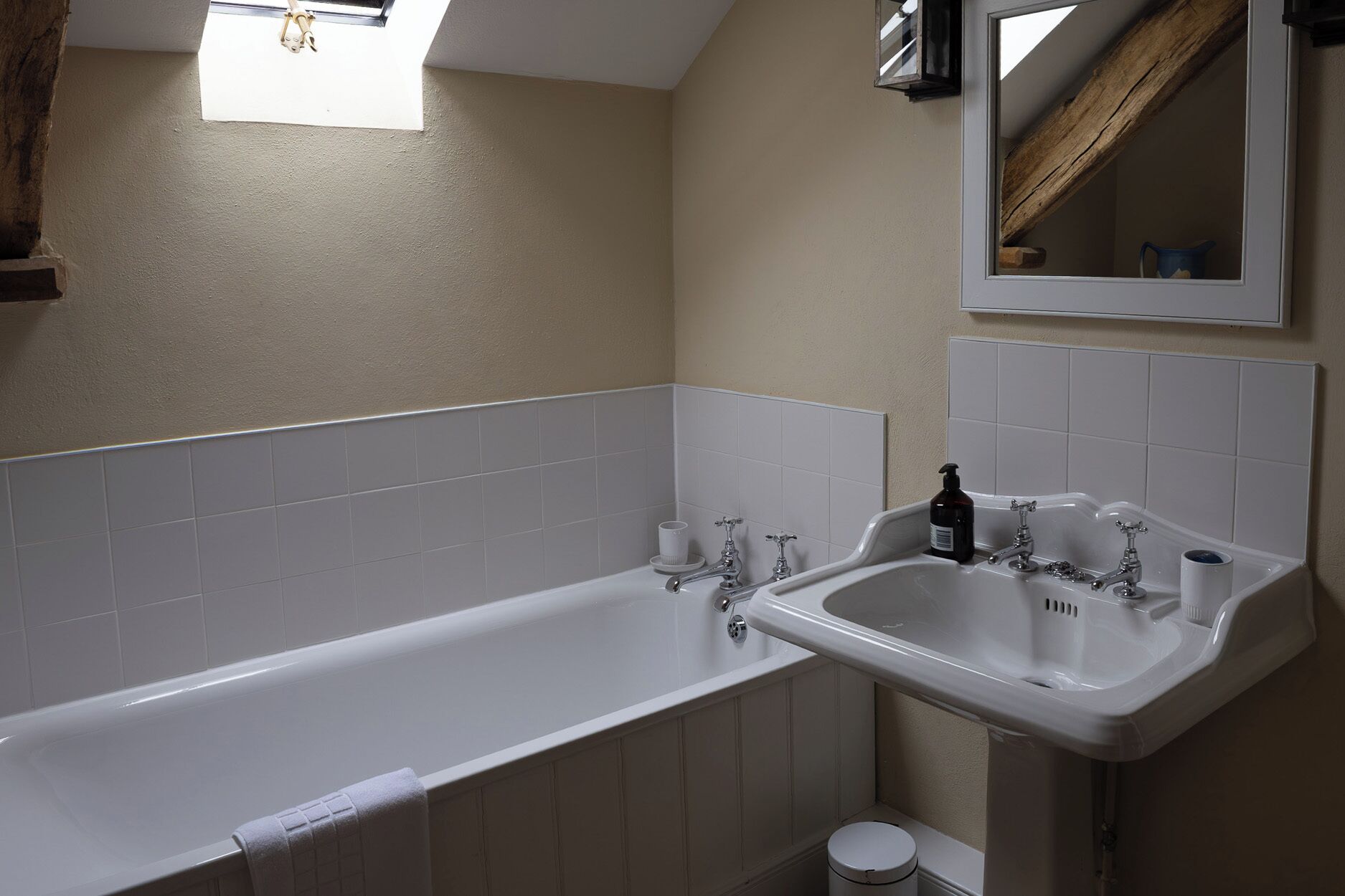 Un baño con bañera, dos lavamanos y un espejo.