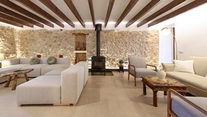 Een moderne woonkamer met een stenen muur, een open haard en een zithoek.
