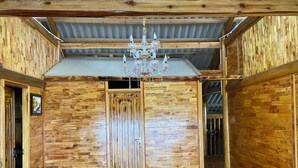 Una habitación con paredes de madera, una puerta grande de madera y un candelabro.