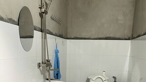 Un baño pequeño con un lavamanos blanco, un inodoro y una ducha.