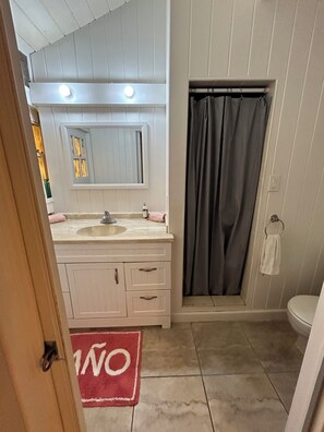 A bathroom with a double sink vanity, a shower curtain, and a toilet. - Shibui Cove, your private retreat to recharge. (St Thomas)