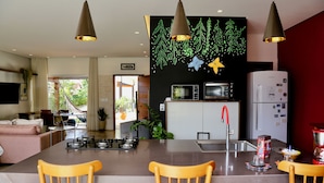 Une cuisine moderne dotée d’un îlot central, un coin repas avec des chaises et un salon avec un canapé.