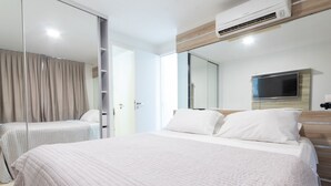 A modern hotel room with a large bed, a TV mounted on the wall, and a sliding door closet. - Ahead Ponta Negra #602 - Apartment by Carpediem (Natal)