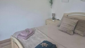 A bedroom with a bed, bedside tables, and wall decorations. - Bed & Breakfast (Maxent)