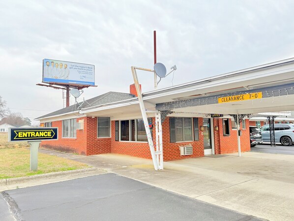 A building with a brick facade, a clear entrance sign, and a 'Clearance 7-0' sign above the entrance.