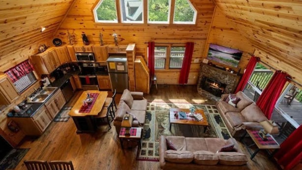 En mysig stuga med ett kök, en matplats och ett vardagsrum.